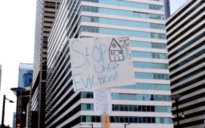 A poster that says "stop unfair evictions" with a hand-drawn house.