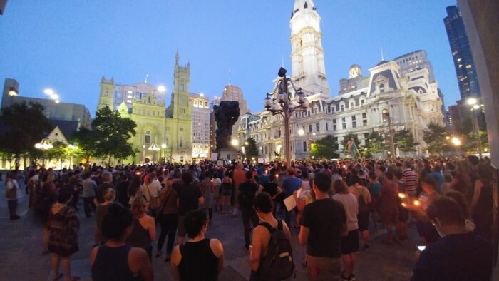 Hundreds of people stand in front of Philadelphia City Hall.